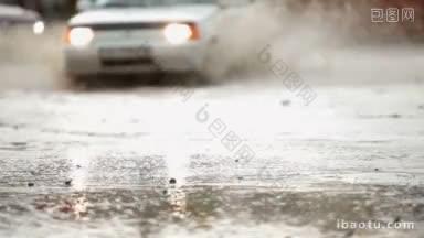 一辆轿车在被洪水淹没的街道上穿过一个大水坑，溅起水花